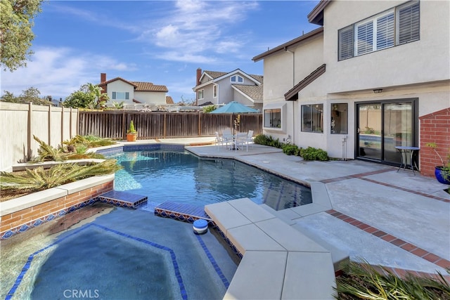 view of swimming pool featuring a patio, a fenced backyard, and a pool with connected hot tub