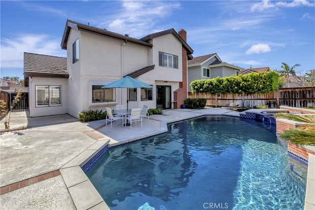 view of swimming pool with a patio area, a pool with connected hot tub, and fence private yard