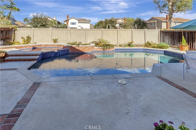 view of pool featuring a pool with connected hot tub, a fenced backyard, and a patio area