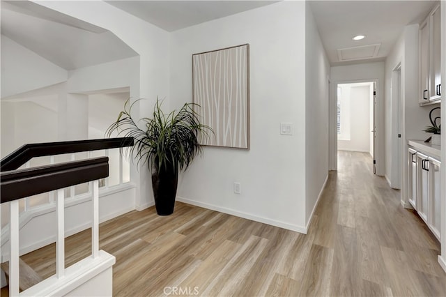 corridor featuring attic access, recessed lighting, baseboards, and light wood-type flooring