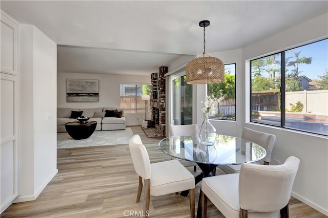 dining space featuring baseboards and light wood-type flooring