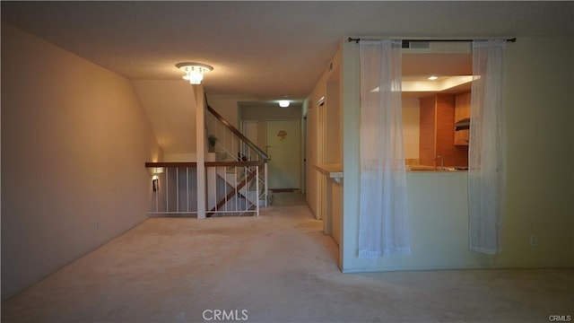 below grade area with visible vents, a textured ceiling, and stairs