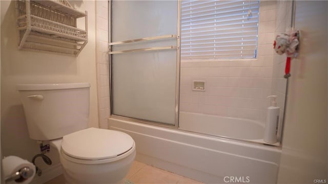 full bath featuring toilet, combined bath / shower with glass door, and tile patterned floors