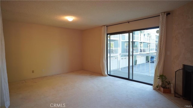 carpeted empty room with a textured ceiling