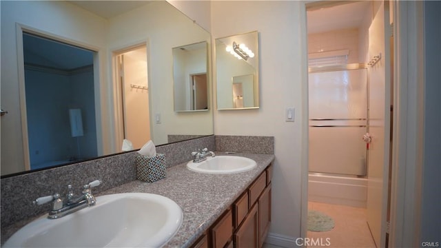 bathroom with double vanity, shower / bath combination with glass door, tile patterned flooring, and a sink