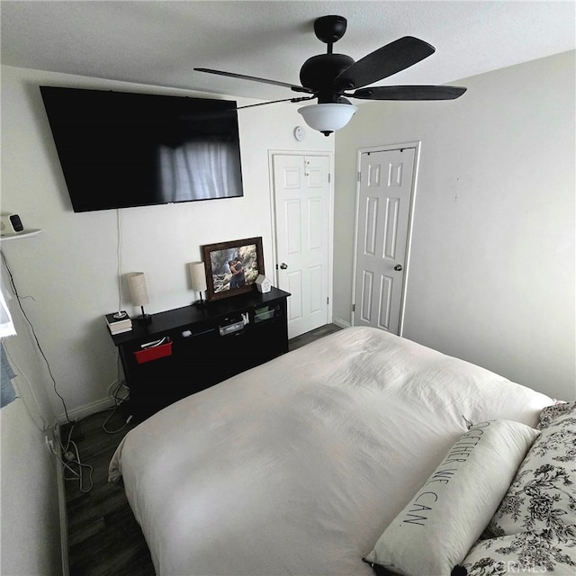 bedroom featuring a ceiling fan, baseboards, and wood finished floors