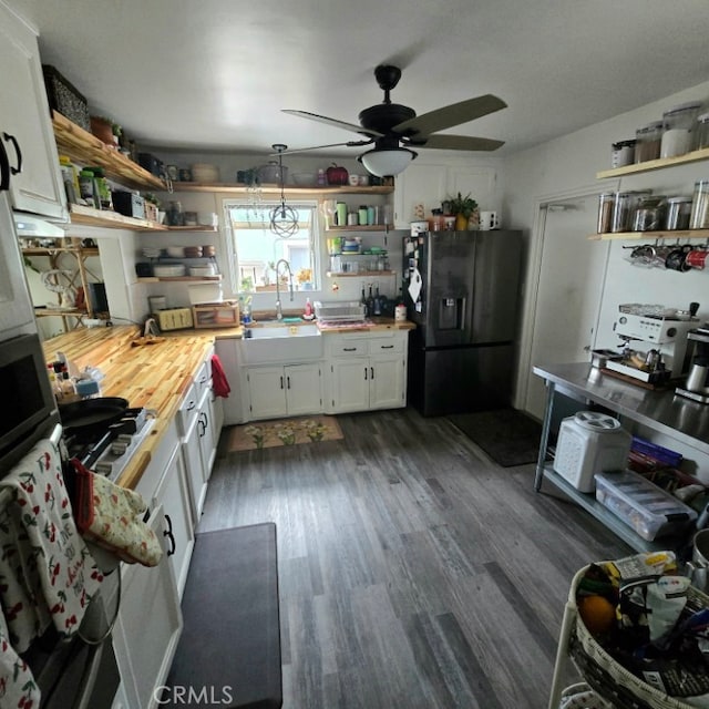 kitchen with white cabinets, dark wood-type flooring, refrigerator with ice dispenser, open shelves, and a sink