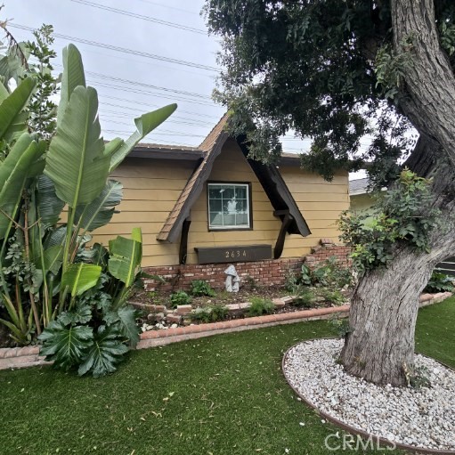 view of side of property featuring a yard and brick siding