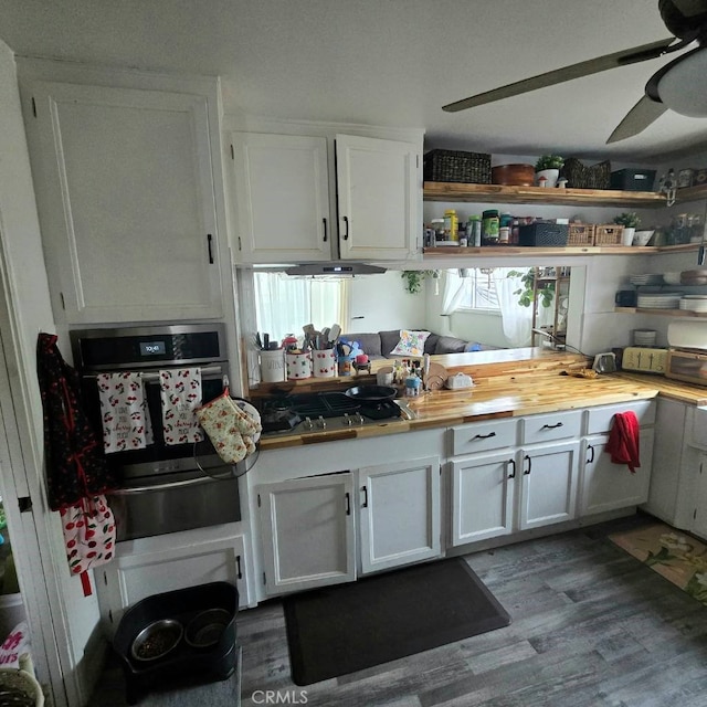 kitchen with dark wood-style floors, a warming drawer, open shelves, appliances with stainless steel finishes, and white cabinets