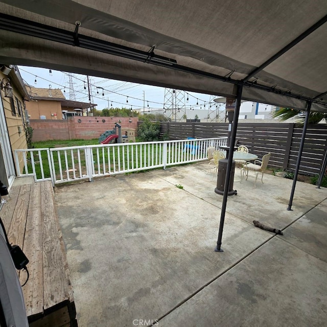 view of patio featuring a fenced backyard and a playground