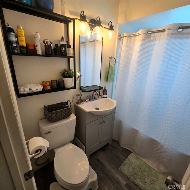 bathroom with toilet, shower / bathtub combination with curtain, wood finished floors, and vanity