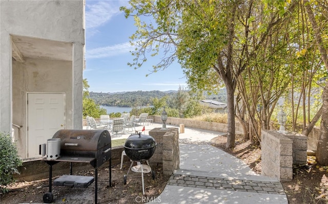 view of patio with a water view and grilling area