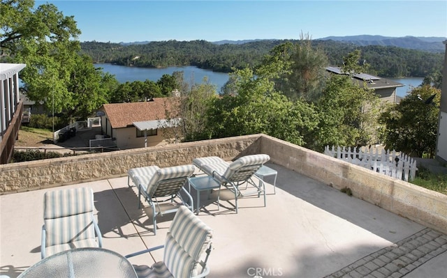 view of patio / terrace featuring a forest view and a water view