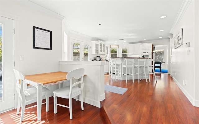 dining area with ornamental molding, breakfast area, wood finished floors, and recessed lighting