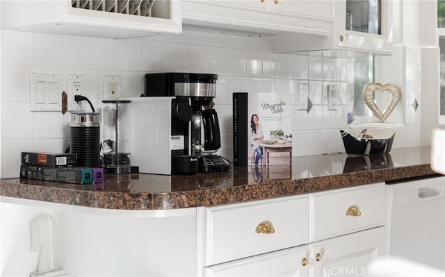 kitchen featuring tasteful backsplash, white cabinetry, dishwasher, and glass insert cabinets