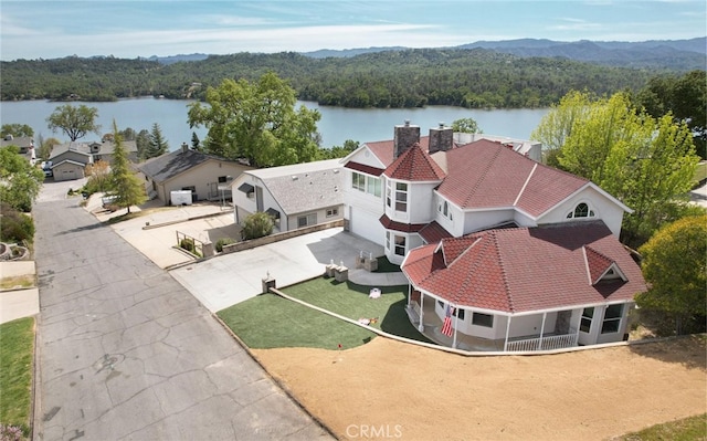 birds eye view of property with a water view and a view of trees