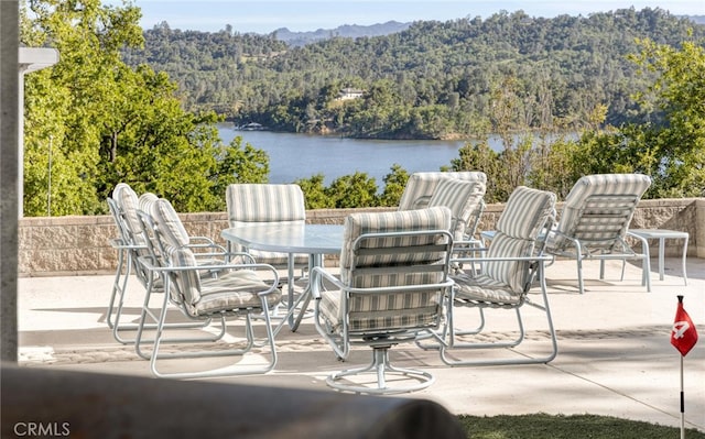 view of patio / terrace with a water view and a view of trees