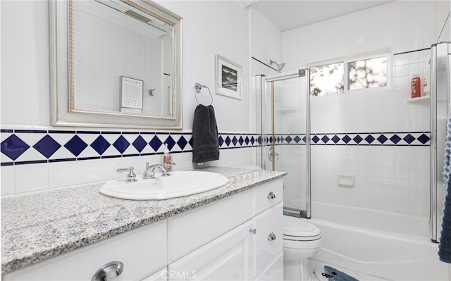 bathroom with enclosed tub / shower combo, vanity, and toilet