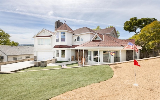 rear view of house featuring concrete driveway, a patio, a yard, and an attached garage