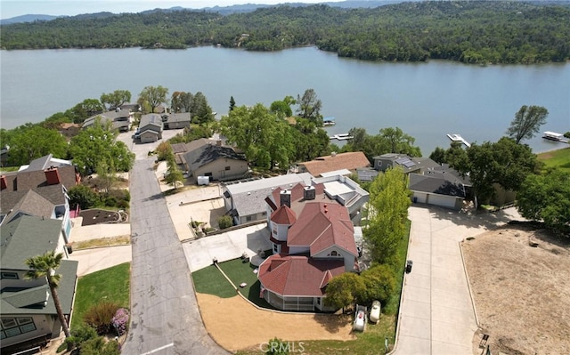 drone / aerial view with a residential view, a water view, and a forest view