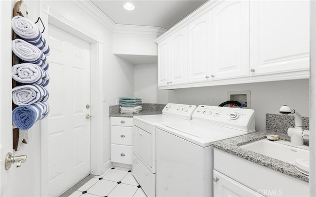 washroom featuring light floors, cabinet space, ornamental molding, washing machine and dryer, and a sink