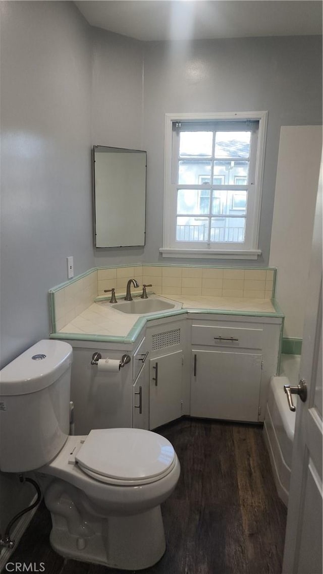 bathroom featuring vanity, wood finished floors, and toilet