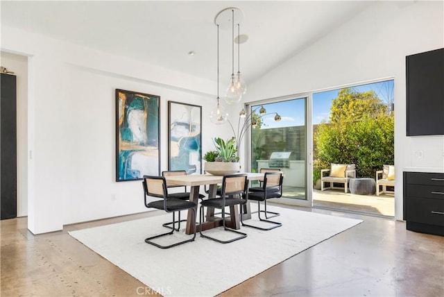 dining space with high vaulted ceiling and concrete flooring