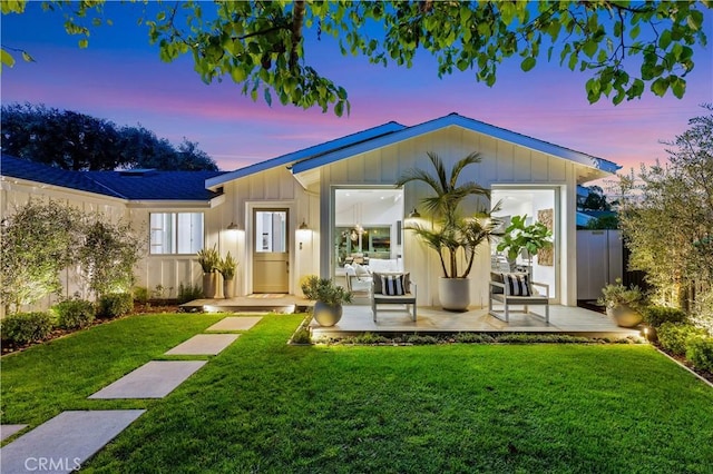 view of front facade with a lawn and board and batten siding