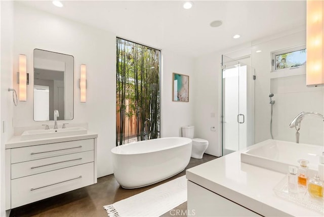 full bath with a freestanding bath, a shower stall, vanity, and recessed lighting