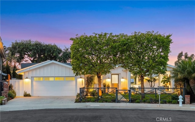 view of front of house featuring fence, driveway, and an attached garage