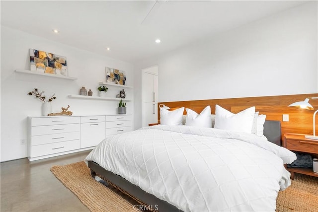 bedroom featuring finished concrete flooring and recessed lighting