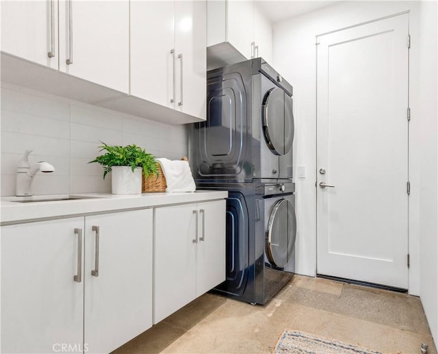 washroom with stacked washer / dryer, a sink, and cabinet space