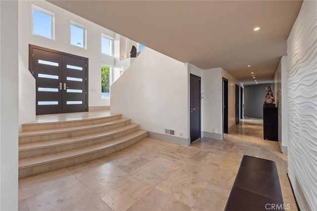 entryway featuring stairs, baseboards, visible vents, and recessed lighting