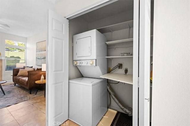 washroom with laundry area, light tile patterned floors, and stacked washer and clothes dryer