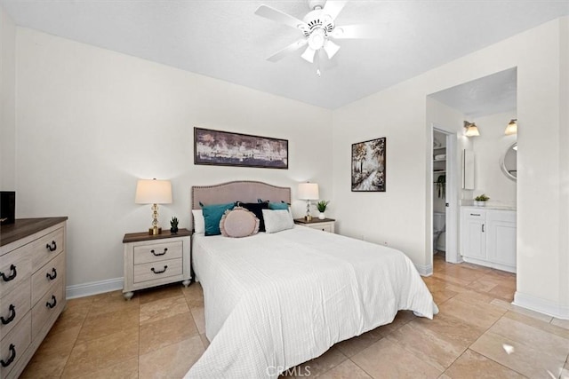 bedroom with a ceiling fan, ensuite bath, and baseboards