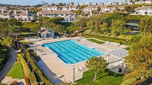 community pool with a residential view, fence, and a patio