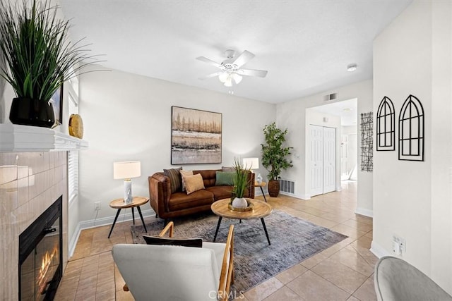 living area with baseboards, visible vents, and a tiled fireplace