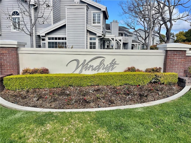 community sign with fence and a lawn