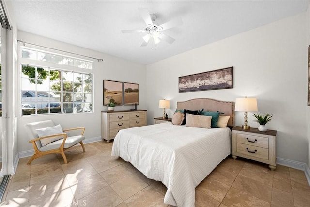 bedroom with ceiling fan, light tile patterned floors, and baseboards