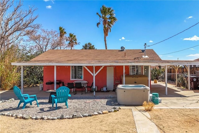 back of house featuring a patio area, fence, and a hot tub