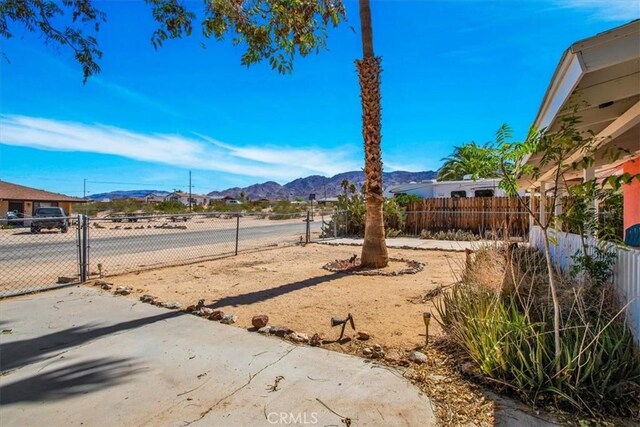 view of yard with a gate, fence, and a mountain view