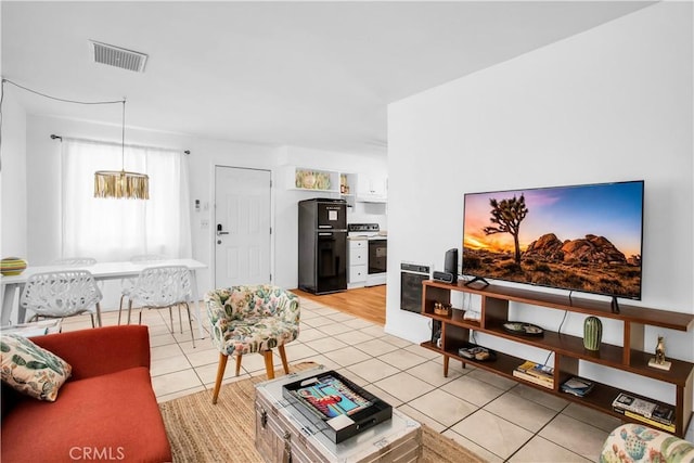 living area with light tile patterned flooring and visible vents