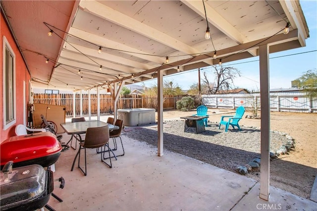 view of patio with a fire pit, outdoor dining space, and a fenced backyard