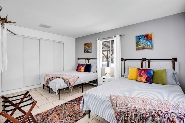 bedroom featuring a closet, visible vents, and light tile patterned floors