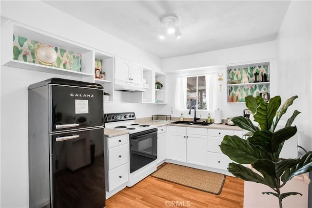 kitchen with electric stove, open shelves, freestanding refrigerator, a sink, and under cabinet range hood