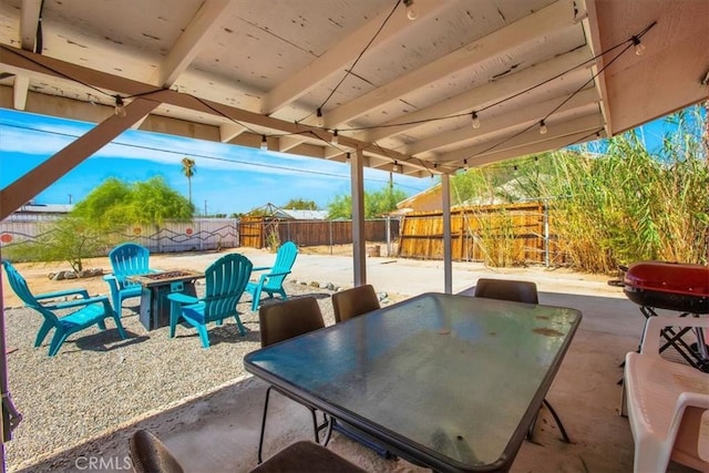 view of patio with an outdoor fire pit, outdoor dining area, and a fenced backyard