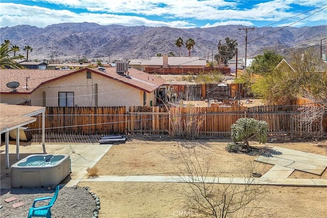 view of yard with fence private yard, a mountain view, and central air condition unit