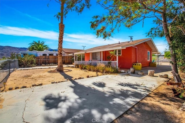 ranch-style house with fence, a porch, and stucco siding