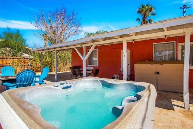 view of swimming pool featuring a hot tub and a patio