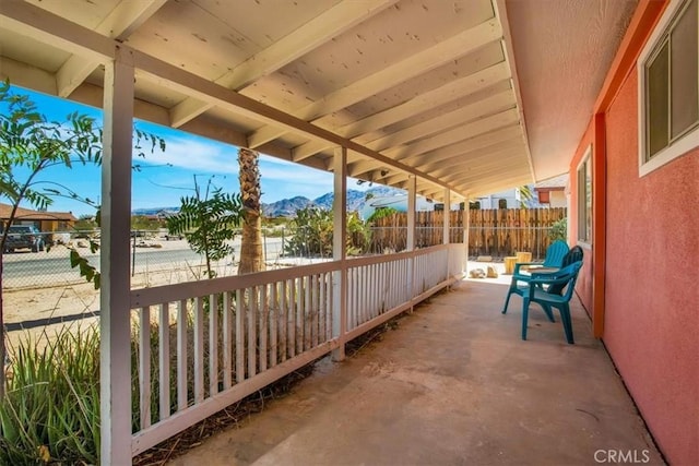 view of patio / terrace featuring fence and a mountain view